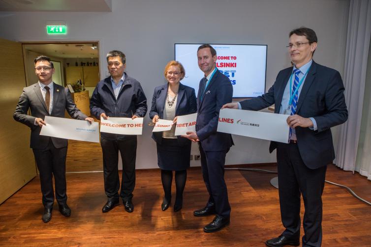 Tibet Airlines' and Finavia's representatives holding freshly cut ribbon.