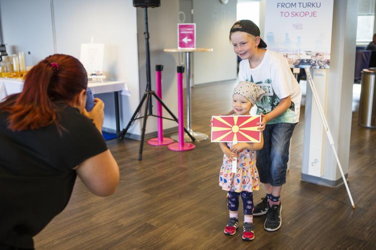 Woman taking a picture of two children.