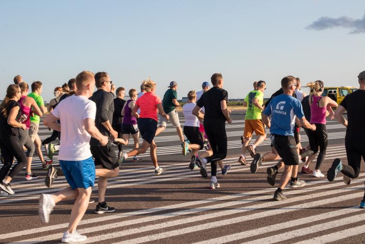 Over fifty people running at runway during cooper test event.