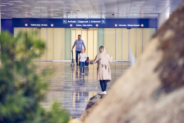 Family in Helsinki Airport arrivals hall.