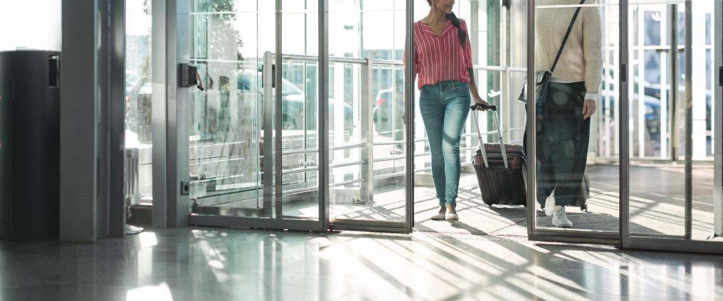 Passenger arriving through opening glass doors. 