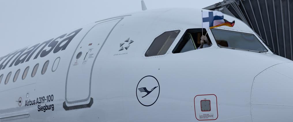 Lufthansan lentokone Oulussa. Crew heiluttaa ikkunasta Suomen ja Saksan lippuapuja